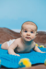 A happy baby of four months lies on a knitted blanket. Baby portrait. child holding his head