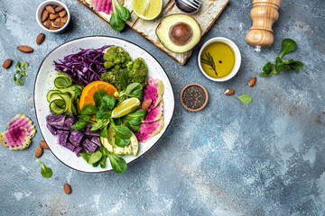 Buddha Bowl with Green vegetable vegan salad with sweet potatoes, broccoli, avocado, purple...