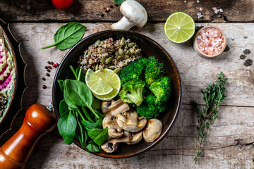 Diet salad made from fresh vegetables broccoli, mushrooms, spinach and quinoa in a bowl. Delicious breakfast or snack, Clean eating, dieting, vegan food concept. top view