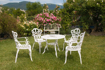 Romantic white table with chairs in the English rose garden