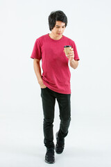 Portrait isolated cutout full body studio shot Asian young handsome teenager male model in casual street style outfit standing smiling look at camera holding disposable coffee cup on white background