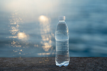 a bottle of clean drinking water on the pier on a sunny summer evening