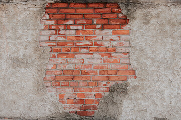 The plaster has crumbled and flaked off the brick wall.