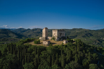 Fototapeta na wymiar Scaliger Castle of d'Illasi in the province of Verona, built in the 10th century. Medieval castle on a hill aerial view. An ancient castle in Italy surrounded by vineyards is a point of interest.