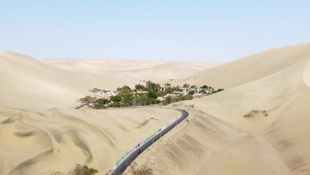 Huacachina, Peru: Aerial drone footage of the stunning Huacachina oasis in the sand desert near Ica in Peru in south America. Shot with a forward motion. 