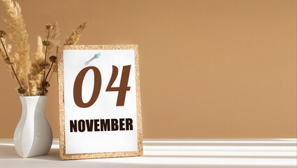 november 4. 4th day of month, calendar date.White vase with dead wood next to cork board with numbers. White-beige background with striped shadow. Concept of day of year, time planner, autumn month