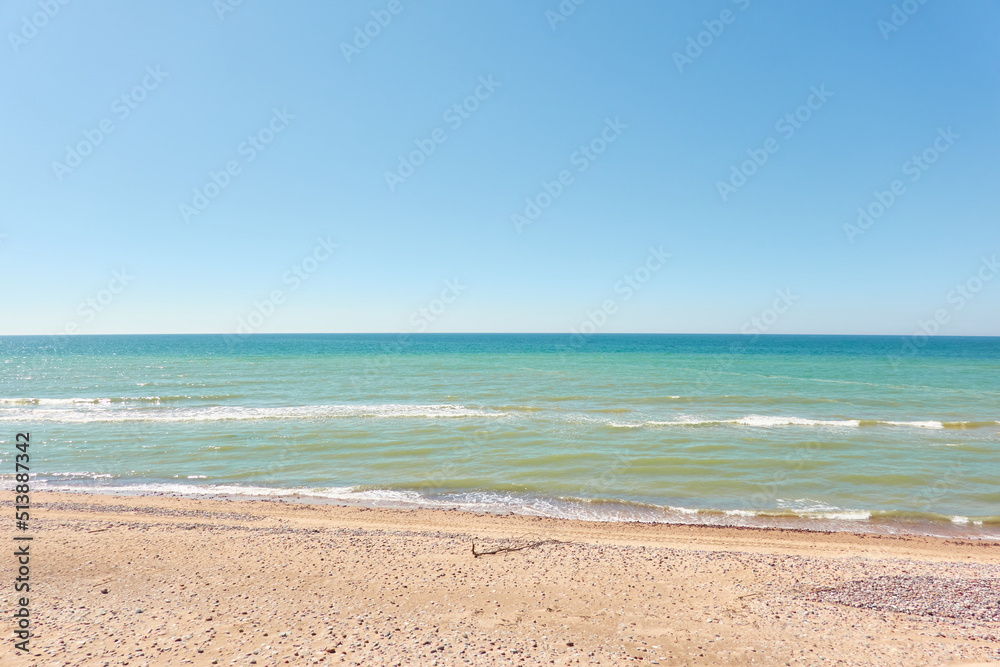 Wall mural baltic sea shore on a sunny day. view from a sandy beach sand dunes). clear blue sky, turquoise wate