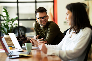 Fototapeta premium Colleagues in office. Businesswoman and businessman drinking coffee.