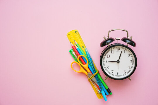 Go Back To School, College Or University. Office Supplies On A Pink Background. Pencils Markers Pens, Scissors, Alarm Clock Black On Pink Canvas. Preparing For Learning.