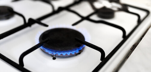 Old gas stove with blue flame. Energy crisis, price increase banner. Save energy.