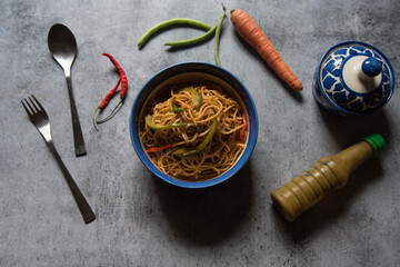 Chinese cuisine Cantonese noodles served in a bowl on a background. Close up, selective focus.