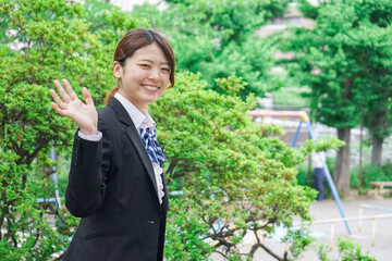 笑顔で手を振る制服姿の学生