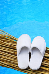 Balneo, spa, hotel, home, wellness slippers with on pier with water background - summer, sauna time - space for text