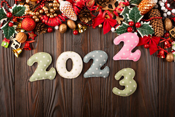 Colorful stitched digits 2022 of polkadot fabric with Christmas decorations flat lay  background on wooden table