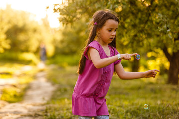 Sweet child child trying to catch soap bubble