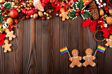 Obraz na płótnie Canvas Christmas background of gingerbread cookie men with rainbow flags on wooden table