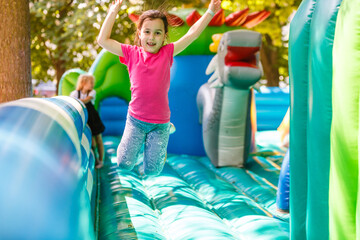 Fototapeta na wymiar A cheerful child plays in an inflatable castle