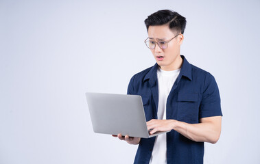 Young Asian man using laptop on white background