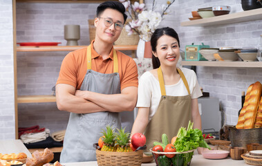 Image of young Asian couple cooking in the kitchen