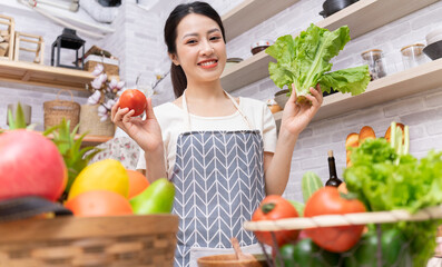 Young Asian woman preparing to cook in the kitchen.