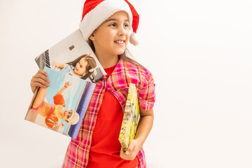 little girl in Santa hat smiling and holding photo canvas in her hand. Christmas concept. Copy space.