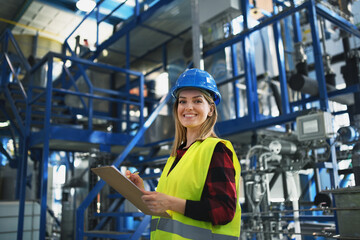 Portrait of female engineer working in industrial factory, doing checkup control.
