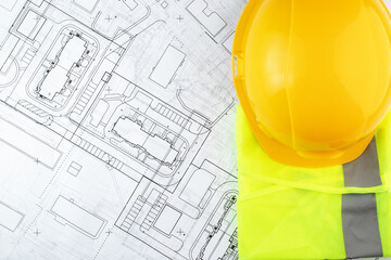 architecture, design and construction, urban development, builder's hard hat and safety vest on architectural drawings