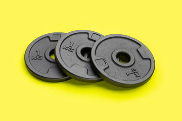 Black weight plates on green background. Gym equipment
