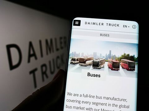 Stuttgart, Germany - 06-25-2022: Person holding cellphone with webpage of automotive company Daimler Truck Holding AG on screen in front of logo. Focus on center of phone display.