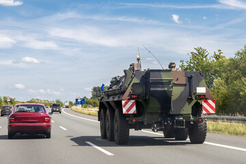 German armoured personnel carrier Fuchs drives military convoy highway road. NATO troops moving...