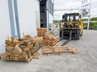 Forklift truck and  wooden pallets outside warehouse (Soft focus)