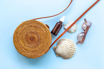 Summer beach background rattan bag with tanning oil and seashells