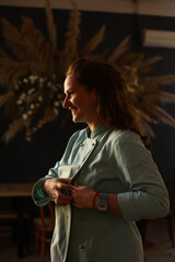 Female chef preparing for work. He puts on an apron coat, fastens buttons and rolls up his sleeves