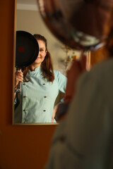 Female chef preparing for work. He puts on an apron coat, fastens buttons and rolls up his sleeves