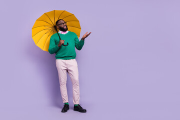 Full length photo of good mood young man look enjoying rainy weather isolated on violet color background © deagreez