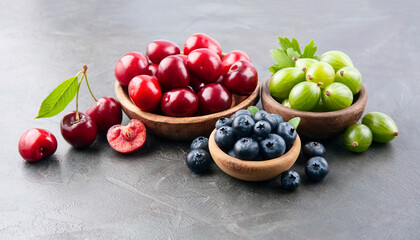 Sweet berry on black backgrounds. Cherry< blueberries and gooseberry in wooden plate.