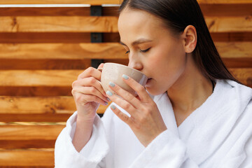 Close-up portrait of a woman drinking tea on a beautiful morning in a spa resort