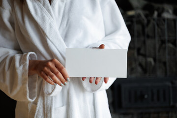 Woman with gift certificate for spa treatment in sauna