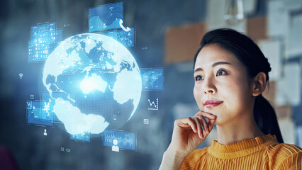 Young Asian woman watching hologram of the planet earth. Global communication network.