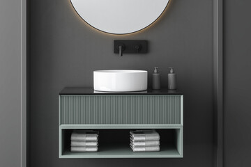 Close up of white sink with oval mirror hanging in on dark wall, modern green cabinet with black faucet in minimalist bathroom, side view. Mock up. 3d rendering

