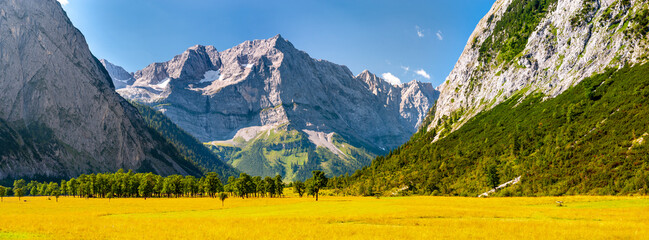 panoramic landscape with mountains behind meadow