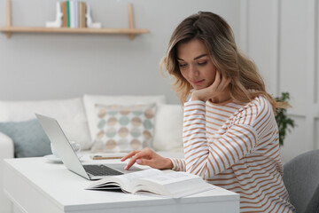 Online test. Woman studying with laptop at home