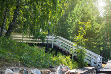 Fototapeta premium Beautiful wooden staircase for descending from the house forest to the lake.