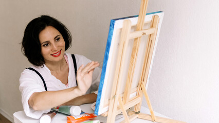 Innovative real female painter using palette knife on big canvas. Modern artwork paint on canvas, creative, contemporary and successful fine art artist drawing portrait