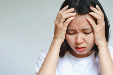 The woman also touched her head with her hand and showed a painful expression. Headaches in adults. Health care concept.