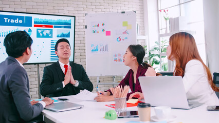 Team leader tries to calm himself while his colleagues are arguing in a meeting.