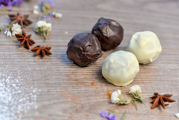 dessert candies made of white and black chocolate on a wooden background