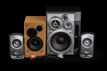Different home loudspeaker systems and audio cables on black background