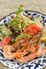 fresh salad with shrimp on a patterned plate macro vertical photo