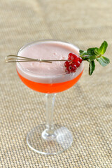 alcoholic cocktail in a glass decorated with currant berries and a mint leaf